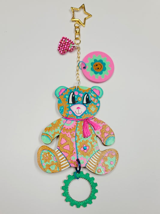 GEAR BEAR – Candy Bag Charm

Sugar, sparkle, and everything nice—that's&nbsp;Candy, the sweetest GEAR BEAR in the bunch! Her gingerbread-toned base pops with candy-colored pinks and aqua, topped with swirls of white frosting stripes. The glittered back and crystal accents add just the right dose of decadent glam.

Each GEAR BEAR comes with three accessory charms—including a&nbsp;signed, hand-painted Geartopia gear tag by artist Megan Aroon—making this a one-of-a-kind treasure where whimsy meets luxury.
