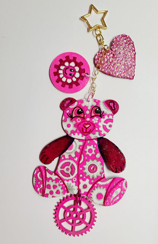 GEAR BEAR – Artisia Bag Charm

Creator of ArtLandia and muse of imagination,&nbsp;Artisia is the original GEAR BEAR. She is painted in vibrant pinks and stunning dark magenta tons and spins with creative energy. The back glitters with artistic flair, while crystals glisten like fresh ideas.

With three charming accents and a&nbsp;hand-painted Geartopia tag signed by artist Megan Aroon, Artisia is a luxe tribute to creativity and whimsy.